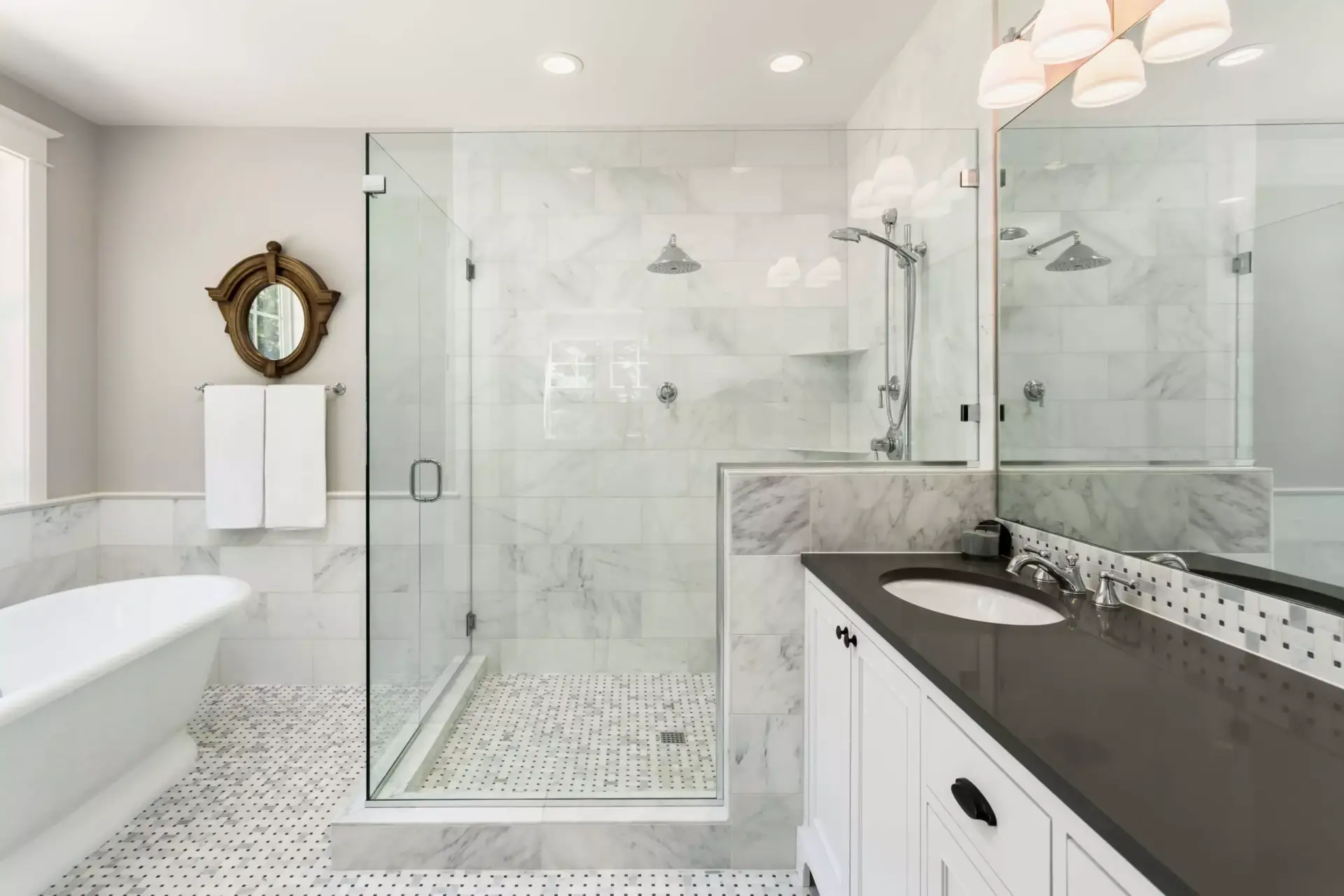 Frameless 90-degree shower enclosure with hinged door, polished chrome hardware, and white marble subway tile.