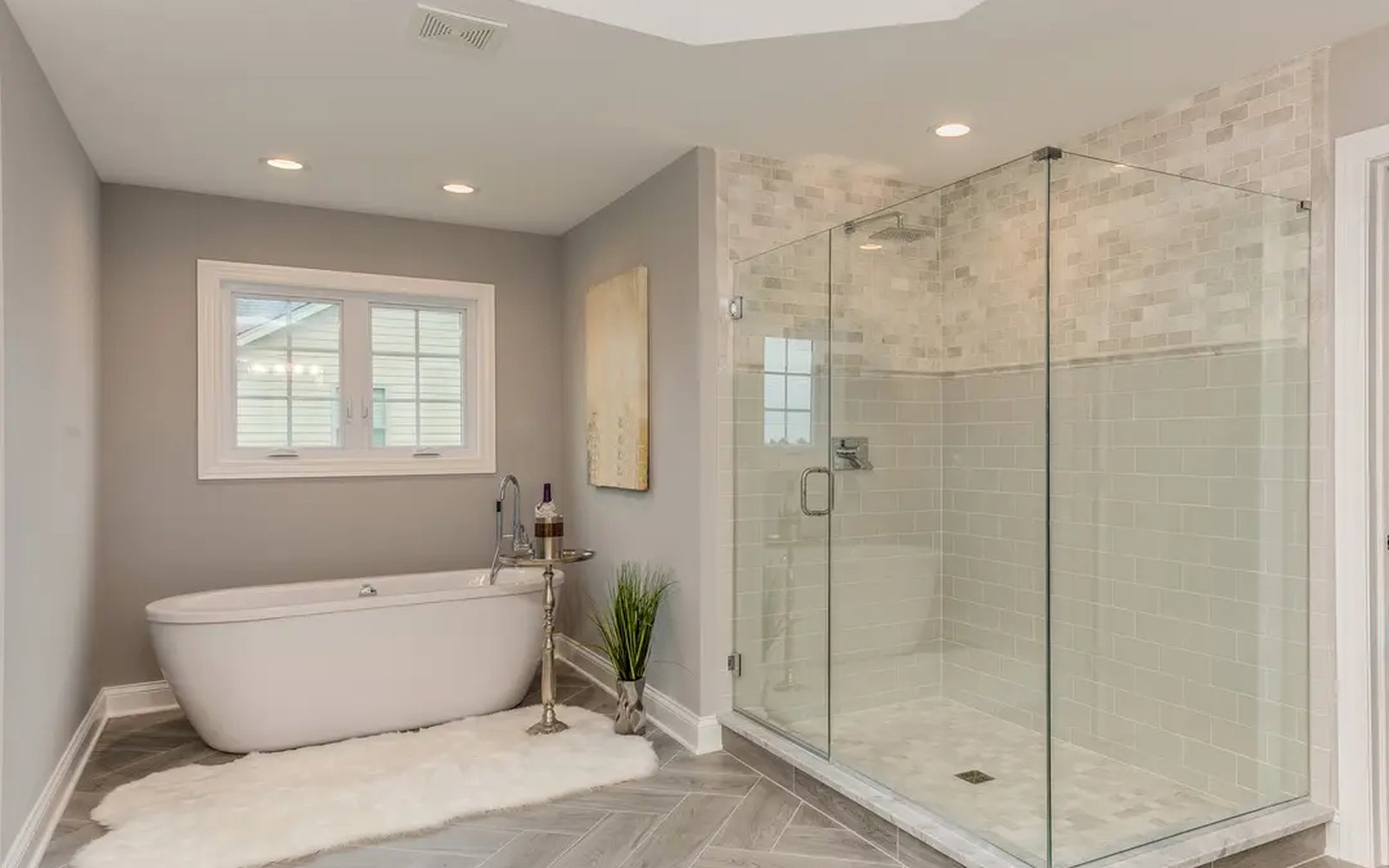 Frameless glass shower enclosure with chrome hardware in a bright residential bathroom — placeholder imagery.